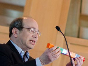 Neil Aronin utiliza piezas de Lego gigantes para explicar como puede que los fármacos silenciadores del gen se rompan en moléculas pequeñas provocando efectos secundarios. Imagen cedida por Lev Blumenstein de CHDI