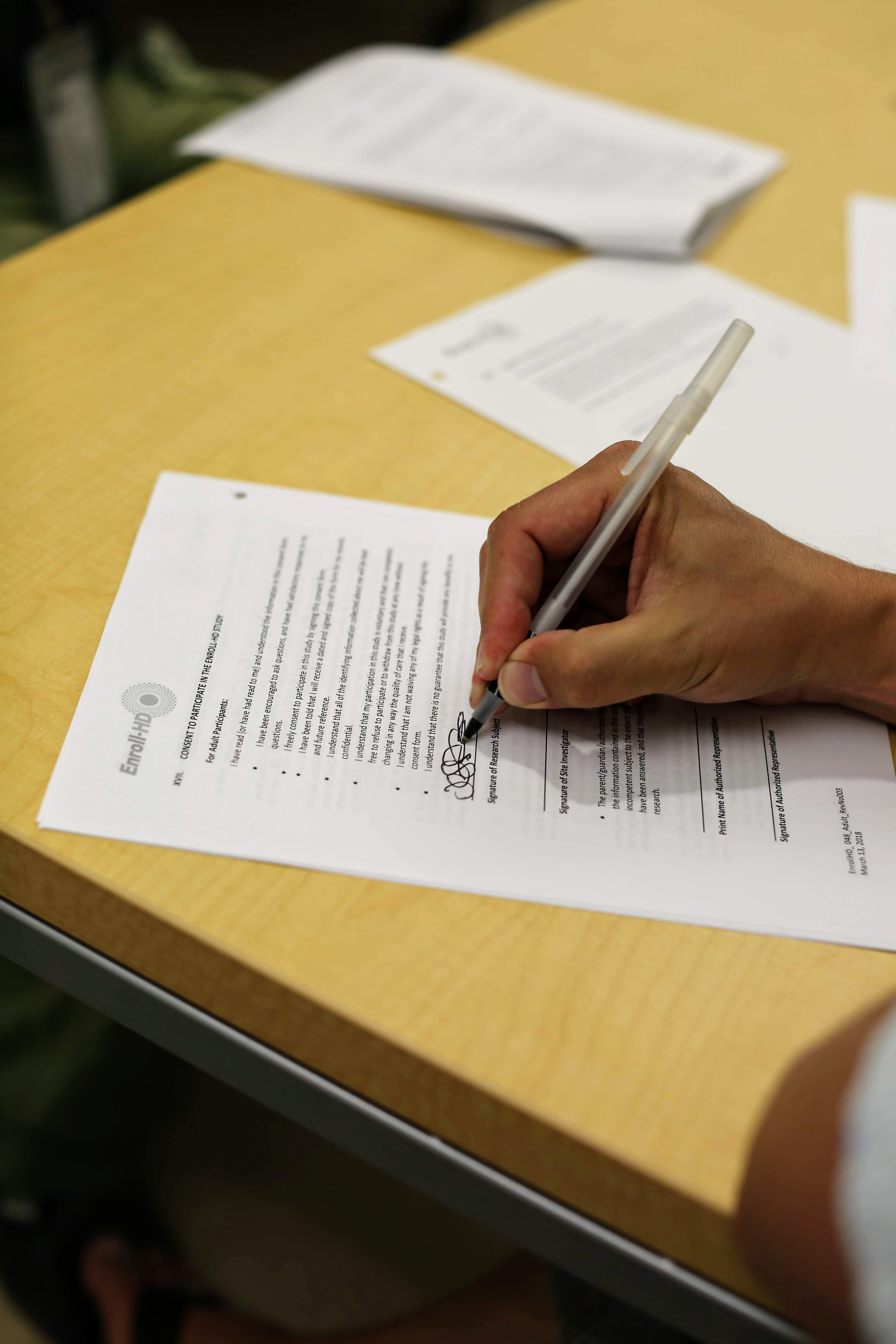 Jeff firma el formulario de consentimiento para el estudio Enroll-HD que es, aunque no lo crea, ¡totalmente entendible! Y, sí, esta es mi firma.